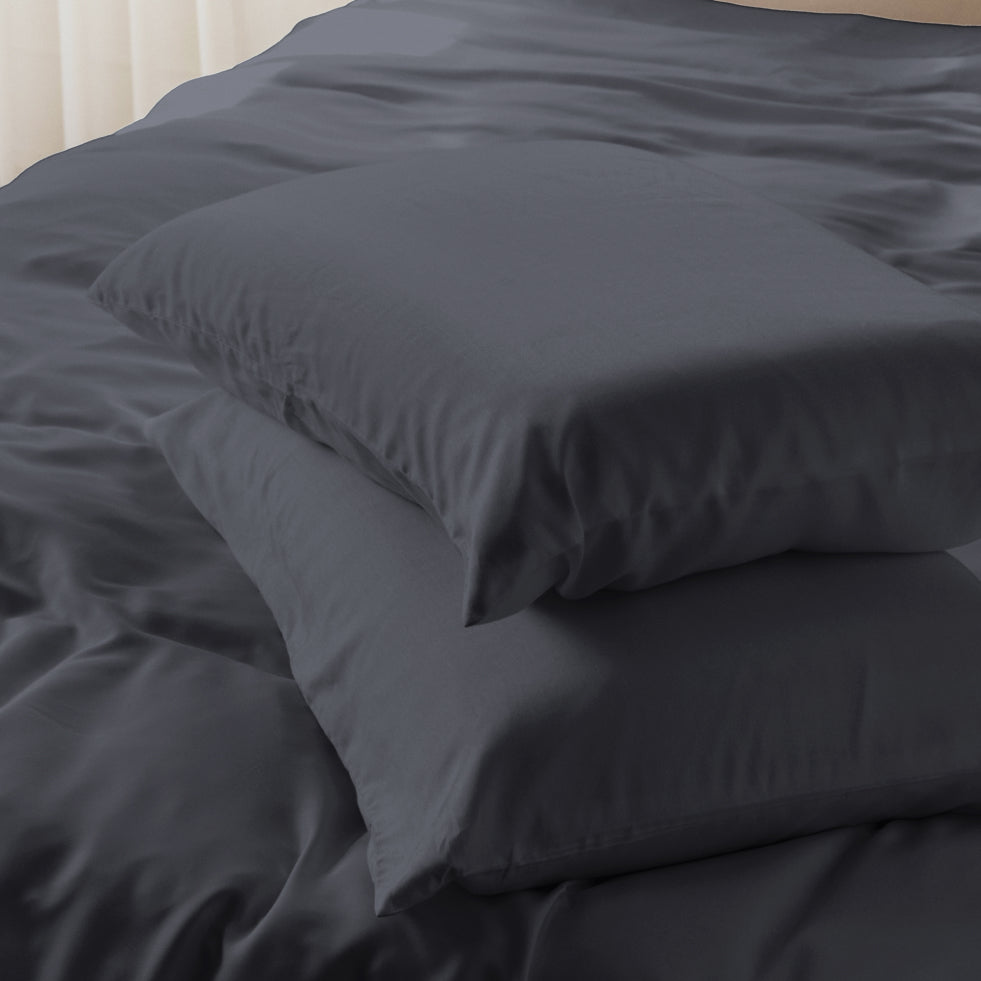 asteroid grey bedding set with two stacked pillowcases on a bed, shown in a close-up view with soft natural light.